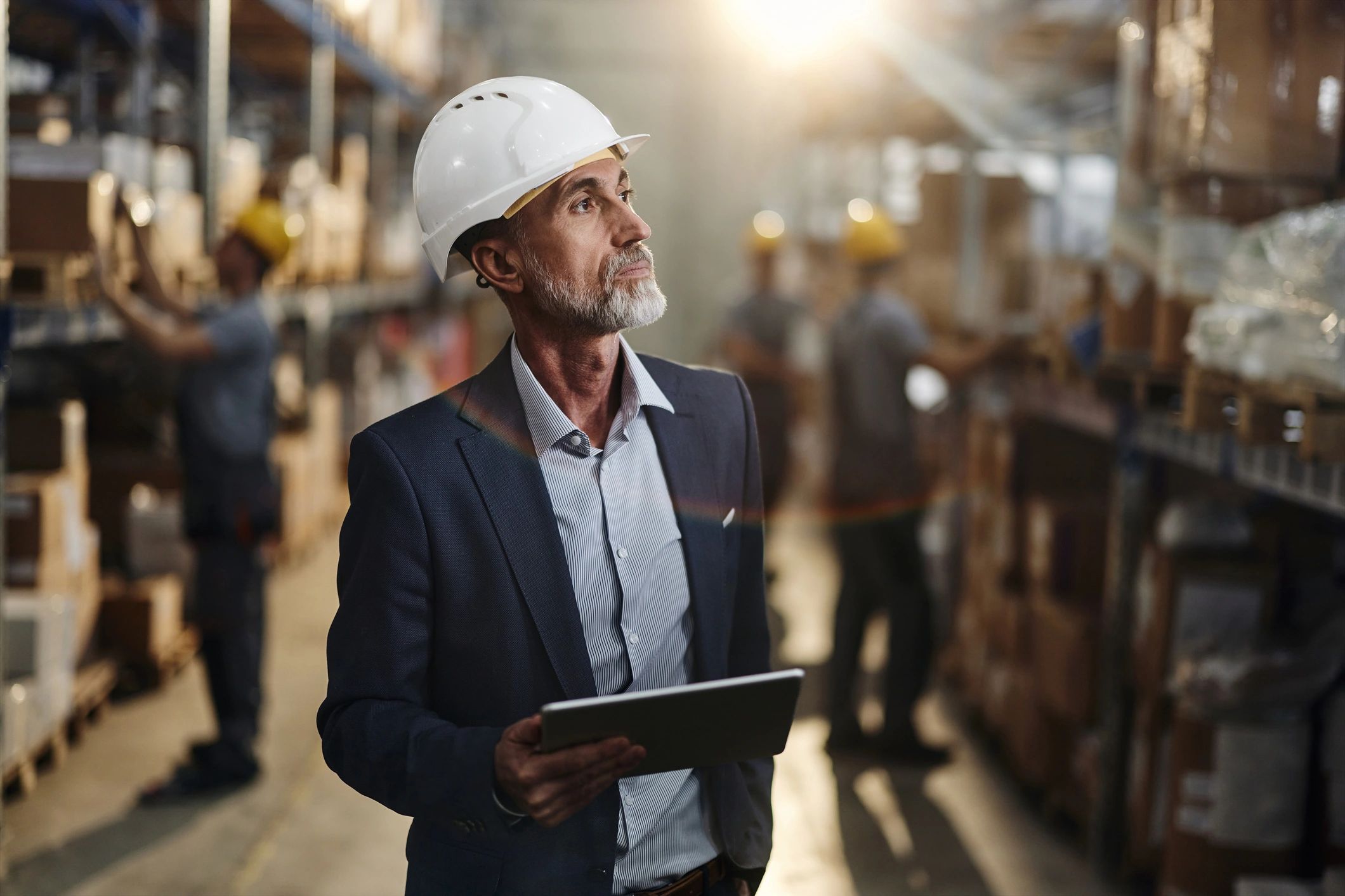 Warehouse inspector using a tablet for quality checks, representing verification and documentation.